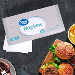 Great Value napkins box on a dark textured surface beside stacked white napkins and burgers