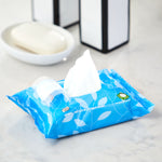Opened resealable pack of Great Value flushable wipes with a single wipe pulled up on a bathroom counter