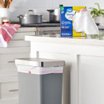 Lifestyle image of a kitchen counter with a Great Value Strong Flex trash bag box on the counter and a lined trash can below