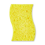 Yellow sponge side of a contoured scrub sponge shown against a white background highlighting porous texture