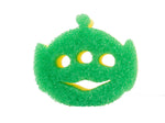 Green alien-shaped scrubby with three circular eye cutouts and a smiling mouth, showing textured surface