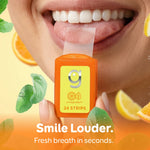 Close-up of a smiling mouth placing a translucent breath strip from an orange Grin Citrus Minty travel case.