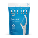 Blue resealable pouch of Grin Double Flosspyx with large white floss pick graphic and recycled-plastic symbol