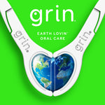 Two white Grin floss picks positioned as a heart shape with an image of Earth inside and brand text on a green background