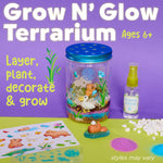 Styled product shot of assembled Grow N' Glow terrarium jar with capybara figures, garden mister and decorative stickers on purple background.