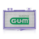 Close-up of translucent purple plastic G•U•M wax case with visible pre-cut wax pieces and G•U•M logo on front