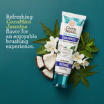Guru Nanda toothpaste tube on a teal background surrounded by coconut pieces, jasmine flowers and neem leaves with flavor text.