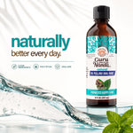 GuruNanda oil pulling oral rinse bottle with stylized water splash and promotional text reading ‘naturally better every day’