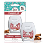 GuruNanda cinnamon expandable waxed dental floss twin packaging with cinnamon sticks beside it