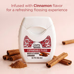 Close product shot of GuruNanda cinnamon flavored expandable floss with cinnamon sticks and powder in foreground