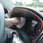 Hand using the gray ribbed Damp Duster to clean inside a vehicle instrument cluster.