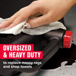 Closeup of a hand using a white STP wipe to clean an oil container spout, red text overlay stating oversized & heavy duty