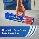 Hand closing a Reynolds Wrap Everyday aluminum foil box on a kitchen countertop