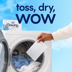 Hand dropping a Downy dryer sheet into a front-load dryer with a Downy Light box visible on top and text saying toss, dry, WOW