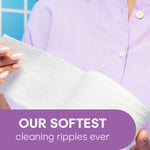Person holding a sheet of Cottonelle toilet paper displaying textured cleaning ripples and a purple banner 'OUR SOFTEST'