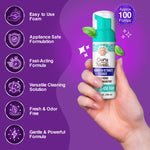 Hand holding a GuruNanda Aligner & Retainer Cleaner foam bottle against a purple background with feature icons and 'approx 100 pumps' callout.