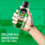 Hand holding a Hot Shot fogger aerosol can against a blurred green background with usage warning text