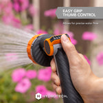 Hand holding HydroTech nozzle spraying a mist with on-image callout for easy grip thumb control