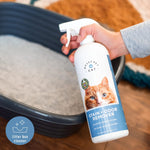 Hand holding a Messy Pet Cat Stain + Odor Remover bottle above an empty cat litter box, label visible