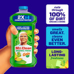 Hand holding a green Mr. Clean 2X concentrated bottle with three promotional callouts about cleaning and freshness