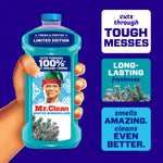 Hand holding a teal Mr. Clean Winter Wonderland bottle with callouts for tough messes and long-lasting freshness
