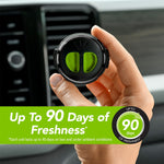 Hand holding a round black car vent diffuser with bright green pads in front of a vehicle air vent and a banner stating up to 90 days of freshness