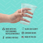 Hand holding a clear Solo plastic cup over teal patterned background with icons listing features like BPA-free and made in the USA.