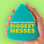Hand holding a teal triangular scrubber against a green background with bold promotional text