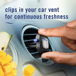 Hand placing a Febreze Car vent clip into a circular car vent with mango cubes and sliced fruit accents