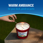 Hand lighting a red Cutter outdoor candle on a patio surface under 'warm ambiance' headline