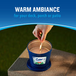Hand lighting a blue Cutter outdoor candle on a concrete block with ‘warm ambiance’ headline above.