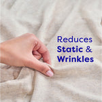 Close-up of a hand pinching soft fabric with text stating 'Reduces Static & Wrinkles' beside it.