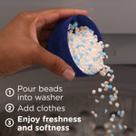 Hand pouring white and blue scent booster beads from a blue scoop above a washing machine with usage caption