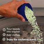Hand pouring pale green Downy scent booster beads from a blue measuring cap into a washing machine drum with usage steps