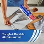 Hands pulling a sheet of Reynolds Wrap aluminum foil from an Everyday box on countertop