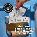 Hand pulling a wipe from a Poo-Pourri flushable wipes box mounted on a toilet paper holder with text promoting the box design