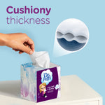 Hand pulling a tissue from a decorative Puffs cube with inset magnified cross-section showing layered thickness