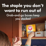 Hand reaching into a pantry shelf toward an Arm & Hammer baking soda box beneath text about grab-and-go boxes