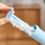 hand pulling a lint-filled insert out of a blue lint remover