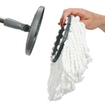 Hand detaching a white microfiber mop head from a gray circular mop plate and handle connector