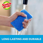 Hand holding a blue Scotch-Brite sponge under running tap water with brand logo and durability claim