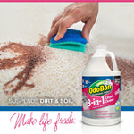 Hand using a blue sponge to scrub a stained carpet with an OdoBan 3-in-1 carpet cleaner jug pictured in foreground