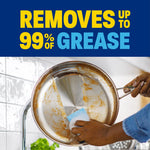 Close-up of hands scrubbing a greasy stainless pan at the sink with bold text claiming removal of up to 99% of grease
