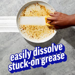 Hand scrubbing a greasy white plate with a sponge showing a clean swath and bold text about dissolving stuck-on grease