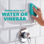 Hand scrubbing white subway tile with a teal sponge and text stating works with just water or vinegar