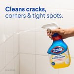 Hand holding and spraying a Clorox Bleach Foamer bottle onto tiled grout with text about cleaning cracks, corners and tight spots.