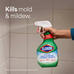 Hand spraying Clorox Clean-Up bottle at tiled surface with text reading "Kills mold & mildew"