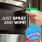 Hand spraying a microwave door with a Fantastik spray bottle and text reading just spray and wipe
