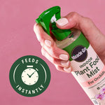 Hand holding and spraying a Miracle-Gro Indoor Plant Food Mist bottle over a pink background with 'feeds instantly' icon.