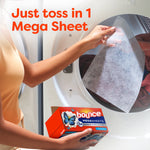 Hand tossing a translucent mega dryer sheet into a dryer with a Bounce Megasheets box visible in foreground